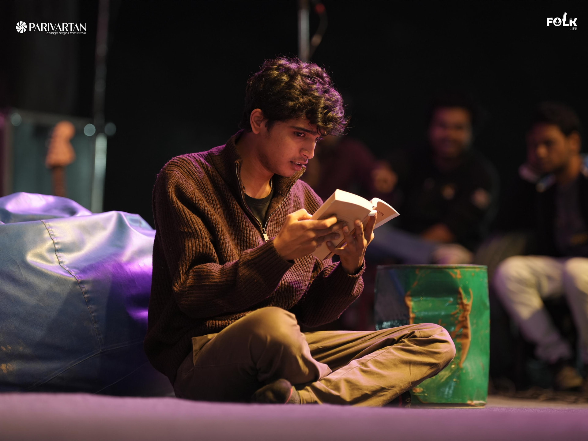 A performer reading from a book during Road to Parivartan at Hare Krishna Mandir